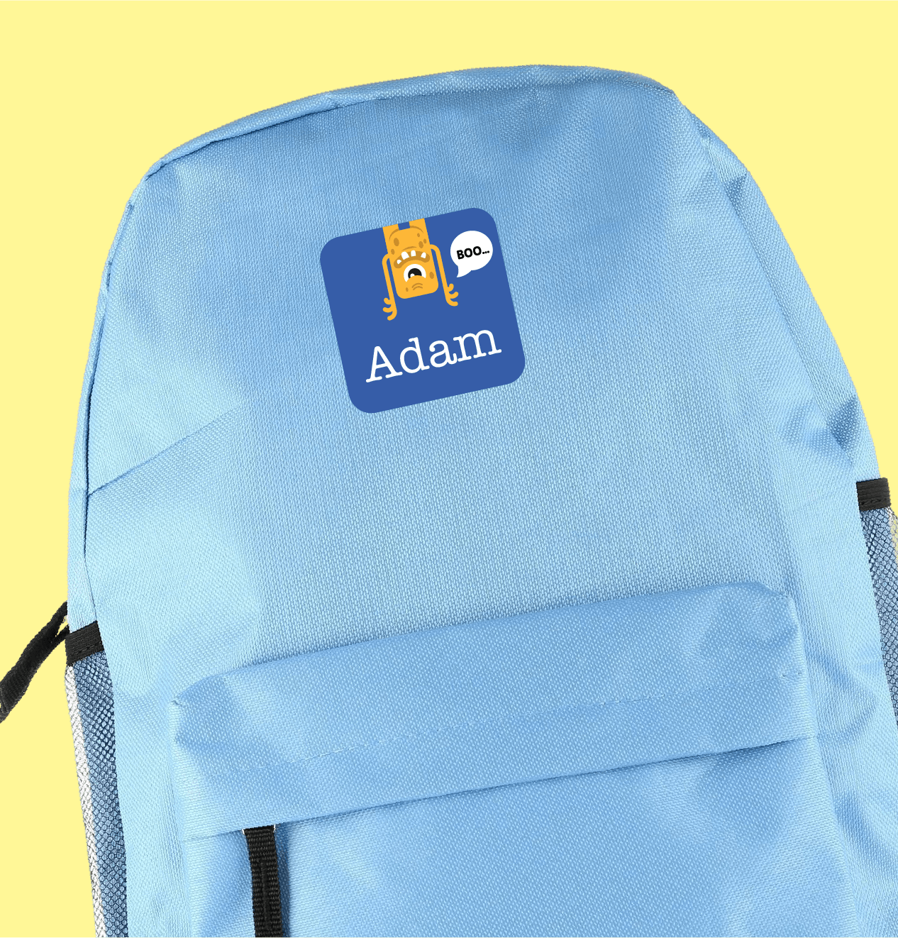 A light blue backpack with a large personalised sticker featuring a cartoon monster and name